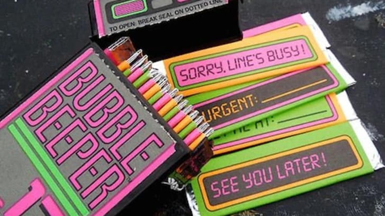 Bubble Beepers gum container filled with gum and some gum sticks spread out