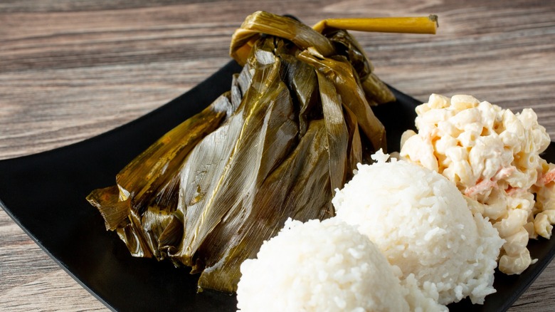 Plate of Hawaiian lau lau pork wrapped in leaves with rice on the side