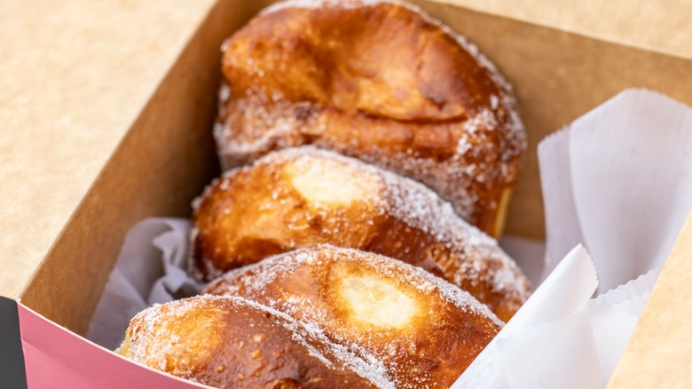Three Hawaiian malasadas or Portuguese donuts in a box