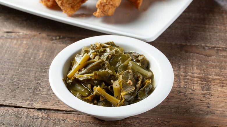 A view of a small white bowl of collard greens.