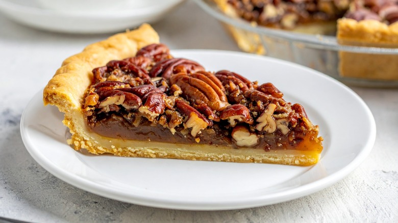 Slice of pecan pie on a white plate