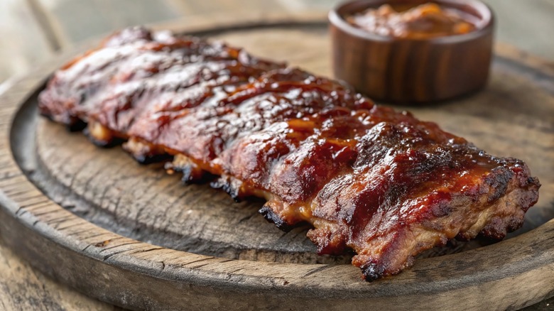 Juicy BBQ Ribs with Tangy Sauce on a wooden cutting board