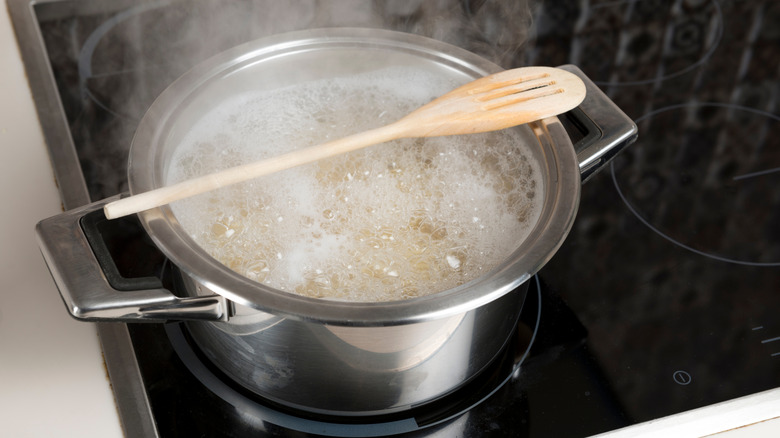 Wooden spoon sitting on top of a pot of boiling water