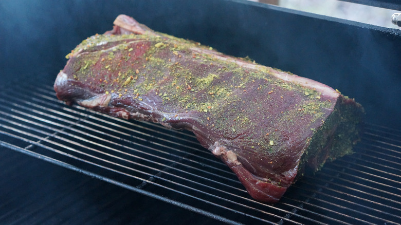 Large section of deer meat on the smoker
