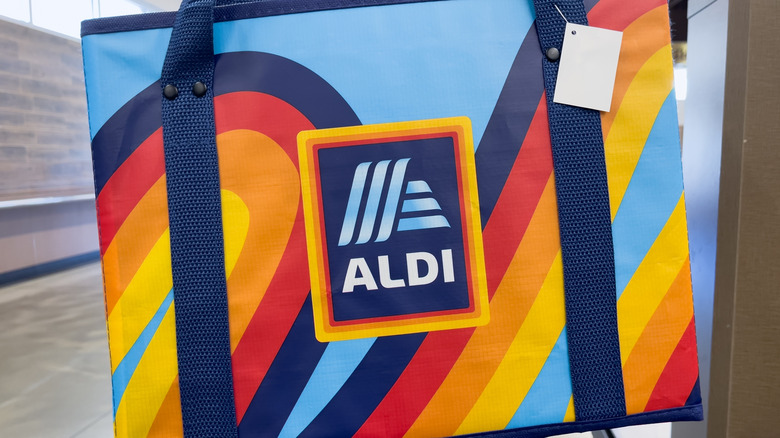 A rainbow color reusable bag, with an Aldi logo on the front