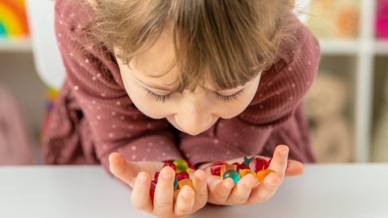 A child holding gummy candies in hand