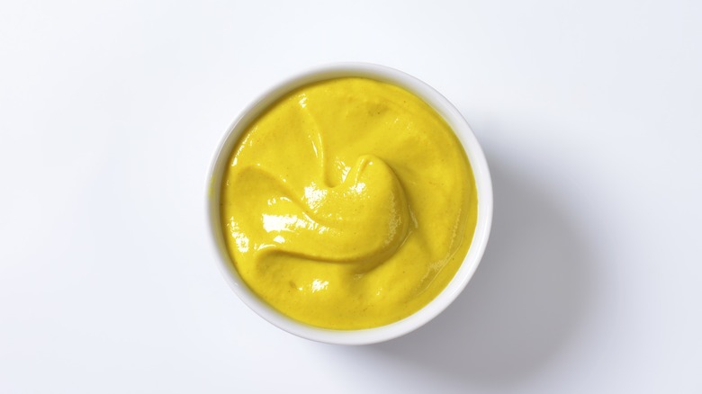 White ramekin of yellow mustard