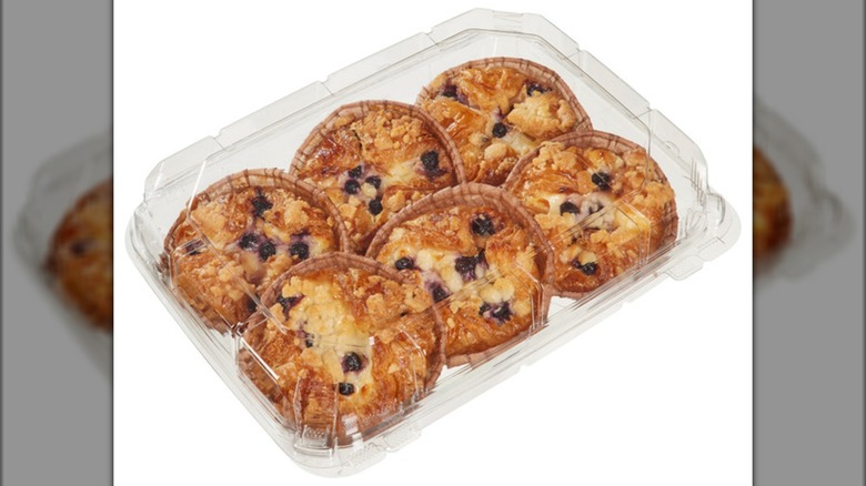 A plastic container with Costco caramelized blueberry cheesecake croissants on a white background.