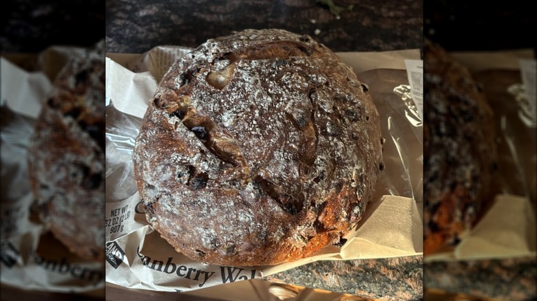 A Costco cranberry walnut round bread loaf on its paper bag