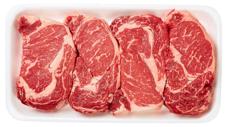Package of Kirkland Signature USDA Choice Beef Ribeye Steaks on white background