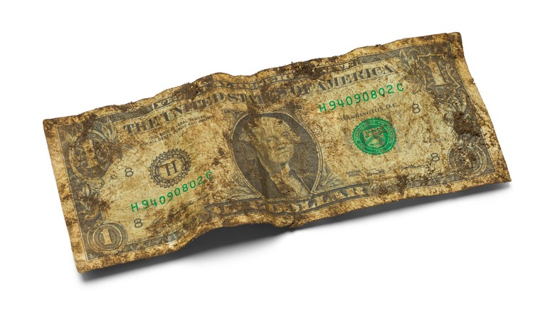 Filthy, wrinkled $1 bill isolated on a white background