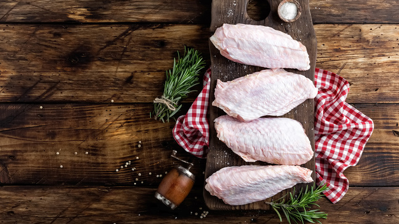 Raw turkey wings on wooden background
