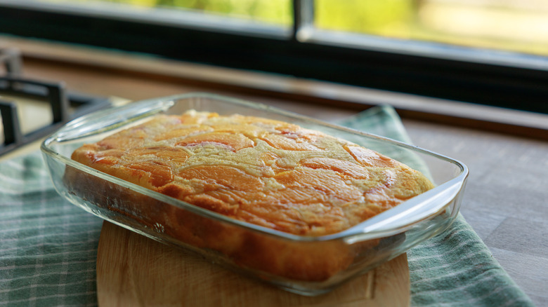 A peach dump cake cooling in a Pyrex baking dish