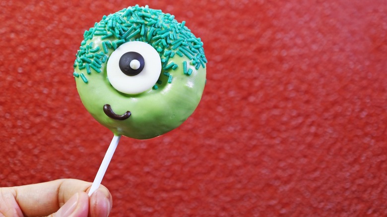 glazed donut cake on a stick that looks like a monster