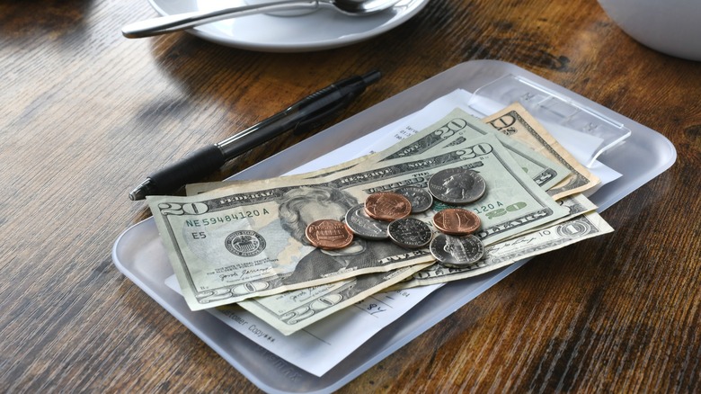 Money with a receipt bill at a restaurant cafe