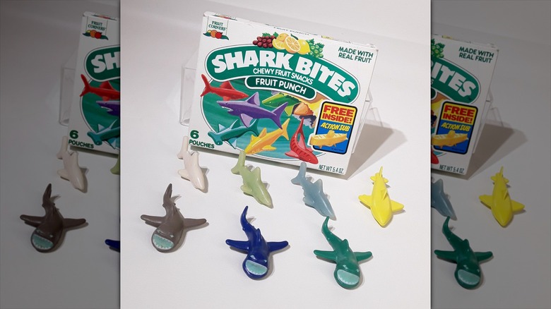 Gummy shark snacks lined up in front of box of Shark Bites Chewy Fruit Snacks