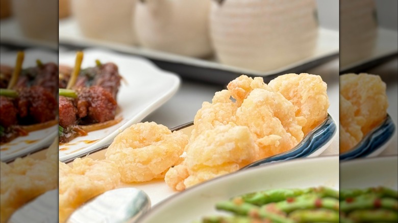 Shrimp rangoons on a plate, shot close-up with other dishes on the table