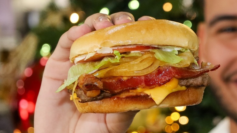 Hand holding Wendy's Cheddar Lovers Bacon Cheeseburger