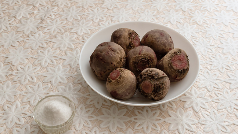 Bowls of whole, raw beets next to glass ramekin of salt