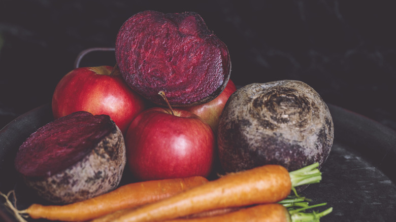 Raw beets, carrots and apples on a tray