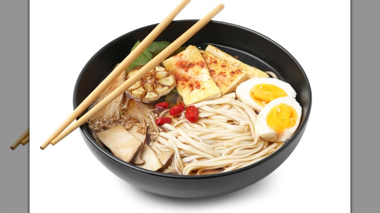 Tasty ramen with enoki and king oyster (eryngii) mushrooms in bowl
