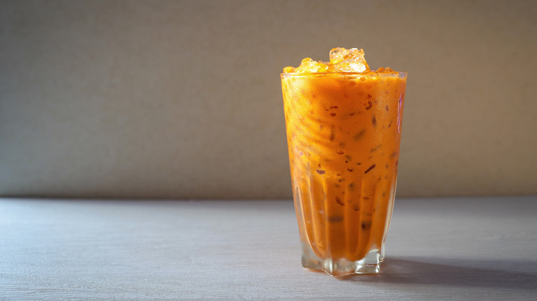 Traditional Thai tea with sweetened condensed in a tall glass filled with ice