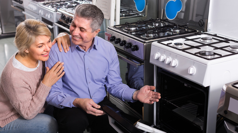 A couple looking at ranges in an appliance store