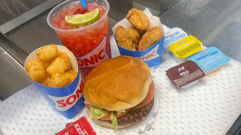 Sonic's $7 Big Deal Meal with a burger, nuggets, tater tots, a drink, and sauces.