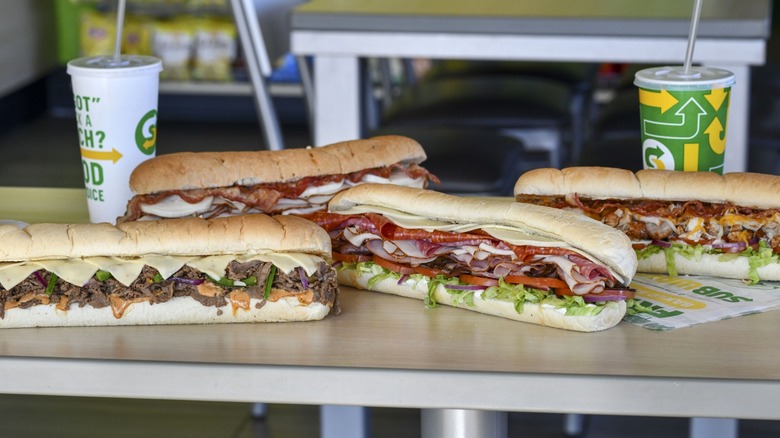 Sub sandwiches on a table in a Subway restaurant.