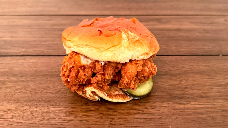 Popeyes fried chicken sandwich on wooden table
