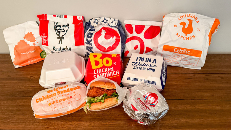 Collection of fast food chicken sandwiches on wooden table
