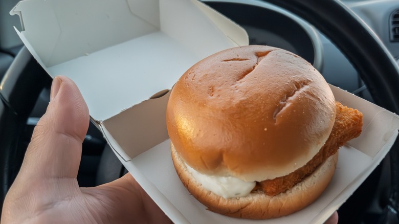 McDonalds Filet-O-Fish Sandwich Held in Hand Inside Car