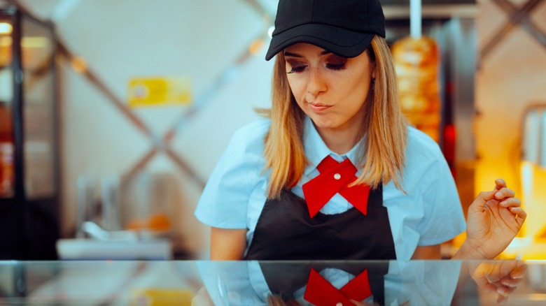 Unhappy Female Fast Food Employee Making an order