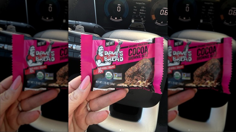 Hand holding Dave's Killer Bread snack bar