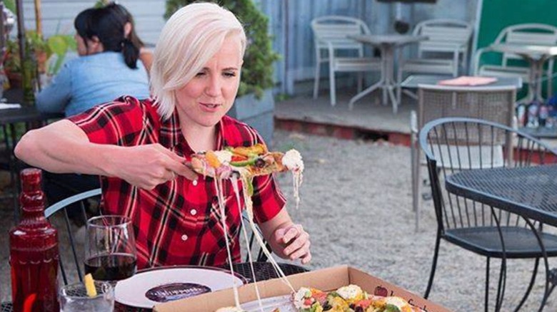Hannah Hart eating a slice of pizza