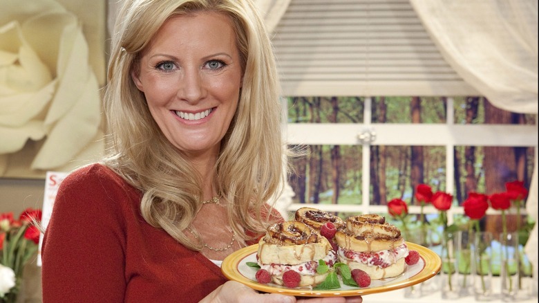 Sandra Lee on the set of "Semi-Homemade Cooking with Sandra Lee" serving a plate of cinnamon buns