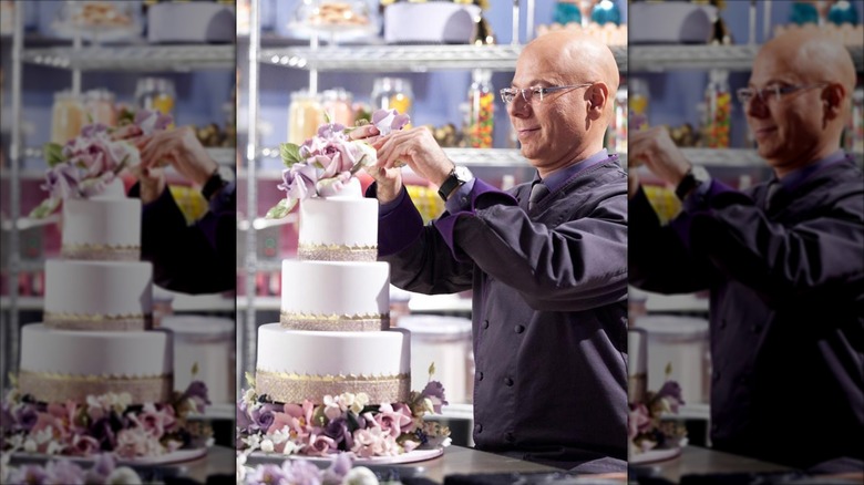Chef Ron Ben-Israel creating a three-tiered cake decorated with flowers on "Sweet Genius" on the Food Network