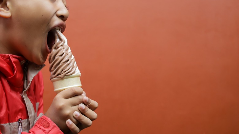 Close-up of a boy enjoying soft-serve chocolate ice cream