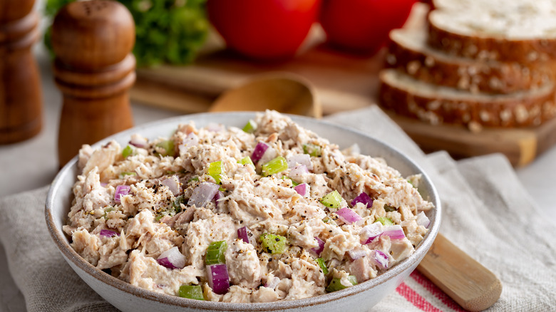 Tuna salad with red onions and celery in a white bowl