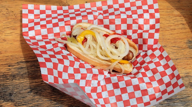 Hot dog with onions on red and white checked paper