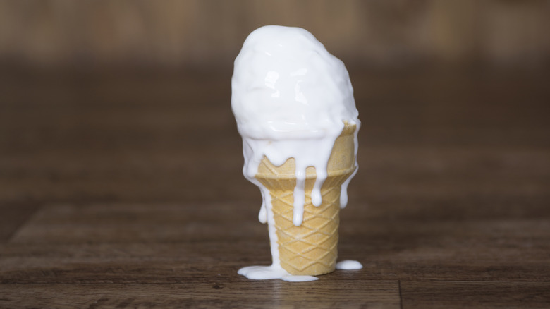 Melting vanilla ice cream cone ice cream dripping down side