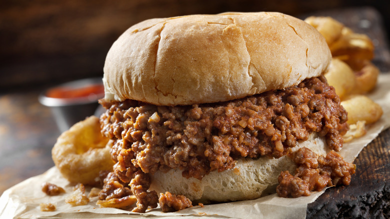 Sloppy Joe Sandwich with onion rings in background