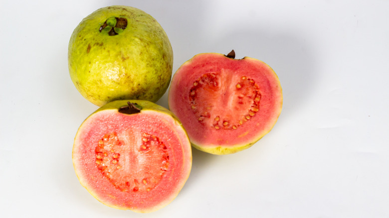 Fresh guava fruits, including one cut in half