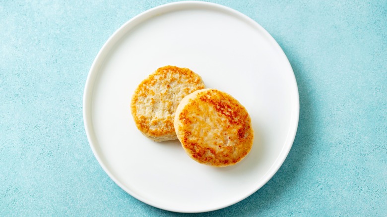 Chicken patties, cutlets on a white plate. Blue background. Top view.
