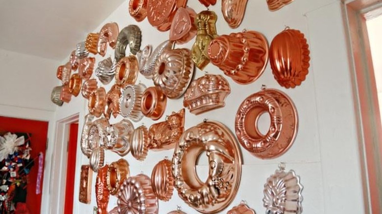 Various copper gelatin molds mounted and arranged on a wall