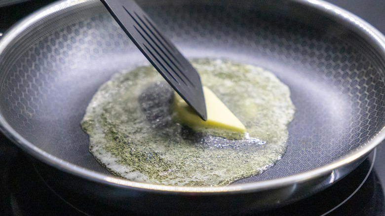 A pat of butter melts in a pan