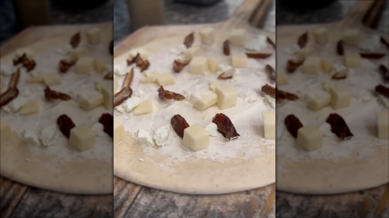 Rise Pizzeria Medjool Date and Chevre pizza on a wooden pizza board