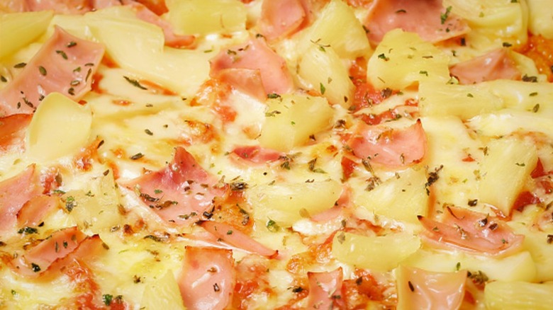 Texture of a delicious fresh hawaiian pizza with sausage, pineapple, cheese, and seasonings