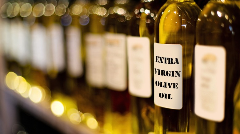 Bottles of extra virgin olive oil lined up on a shelf