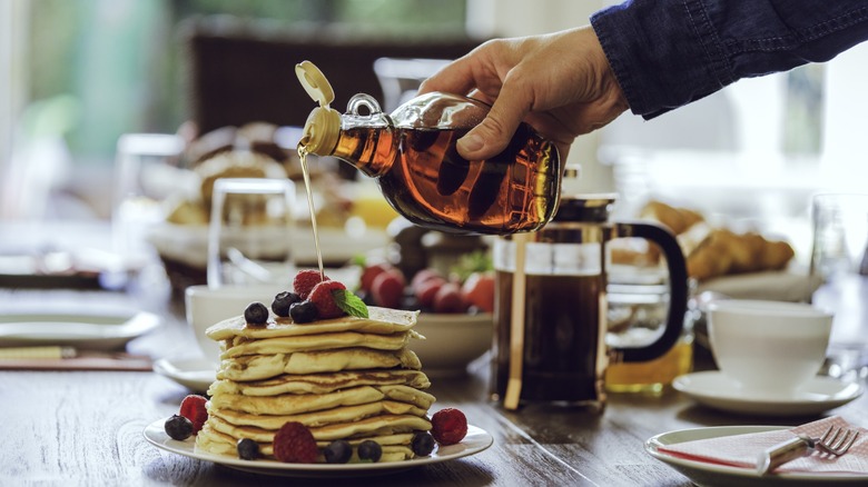 Stack of Pancakes with Maple Syrup being poured on them